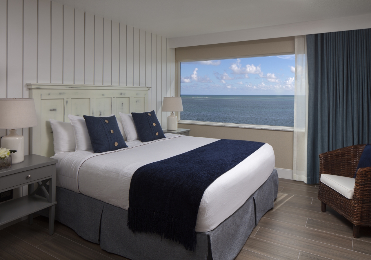 King bed with a large window that you can see the ocean from