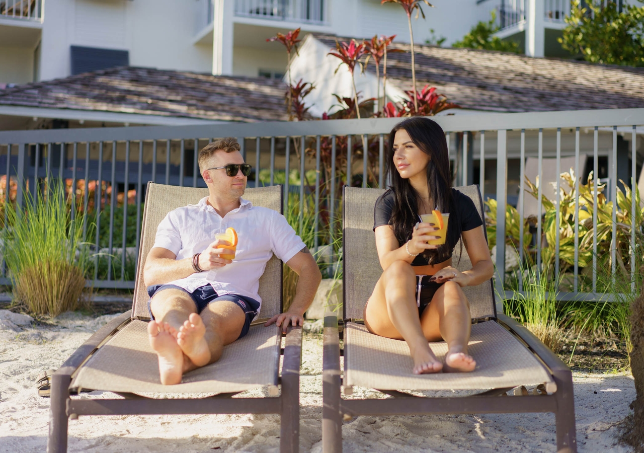 couple lounging on chairs sipping drinks