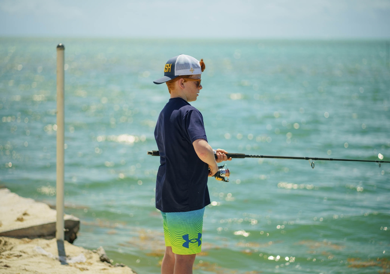 child fishing off of a pier