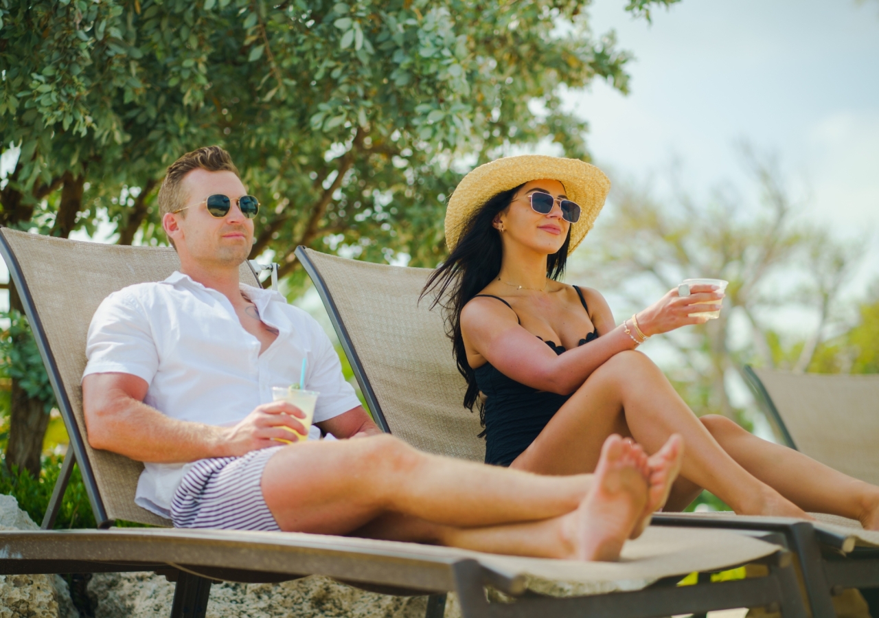 couple lounging chairs with drinks on the beach