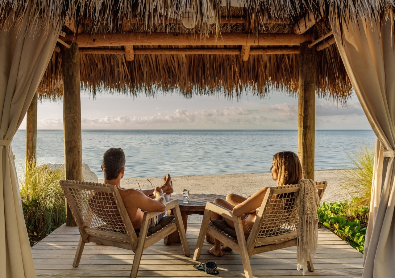 couple lounging in a lenai by the ocean