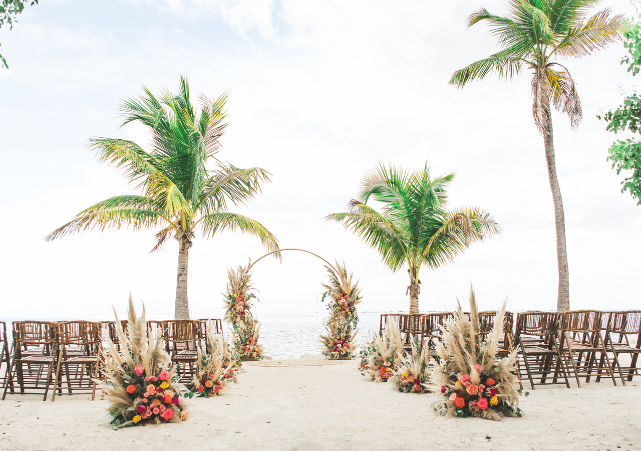 beach setting with wooden chairs and a wedding altar