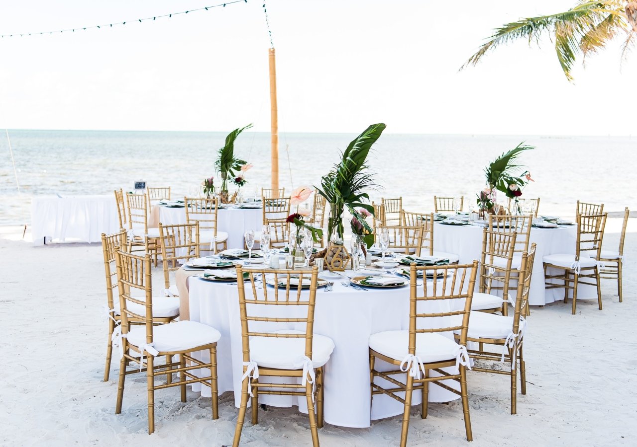 wedding table set up for a rehearsal dinner on the beach