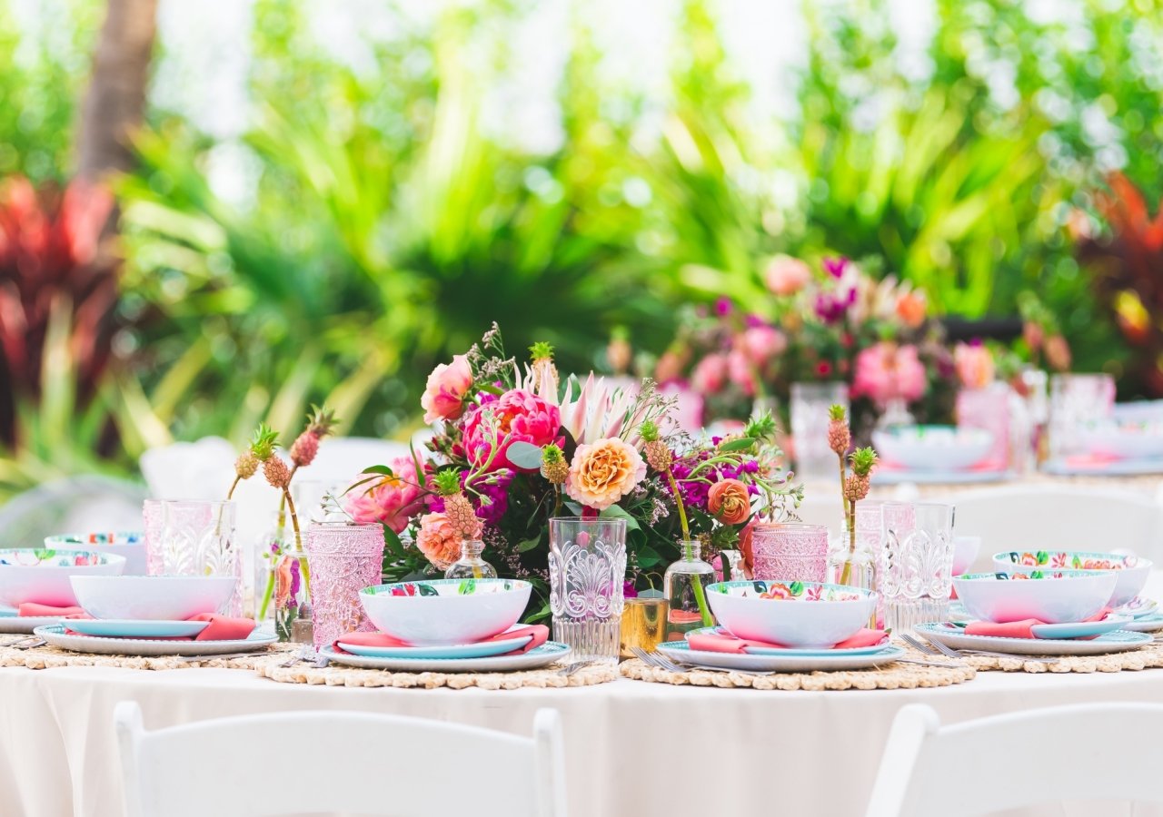 table set with colorful china and flowers for a wedding rehearsal dinner
