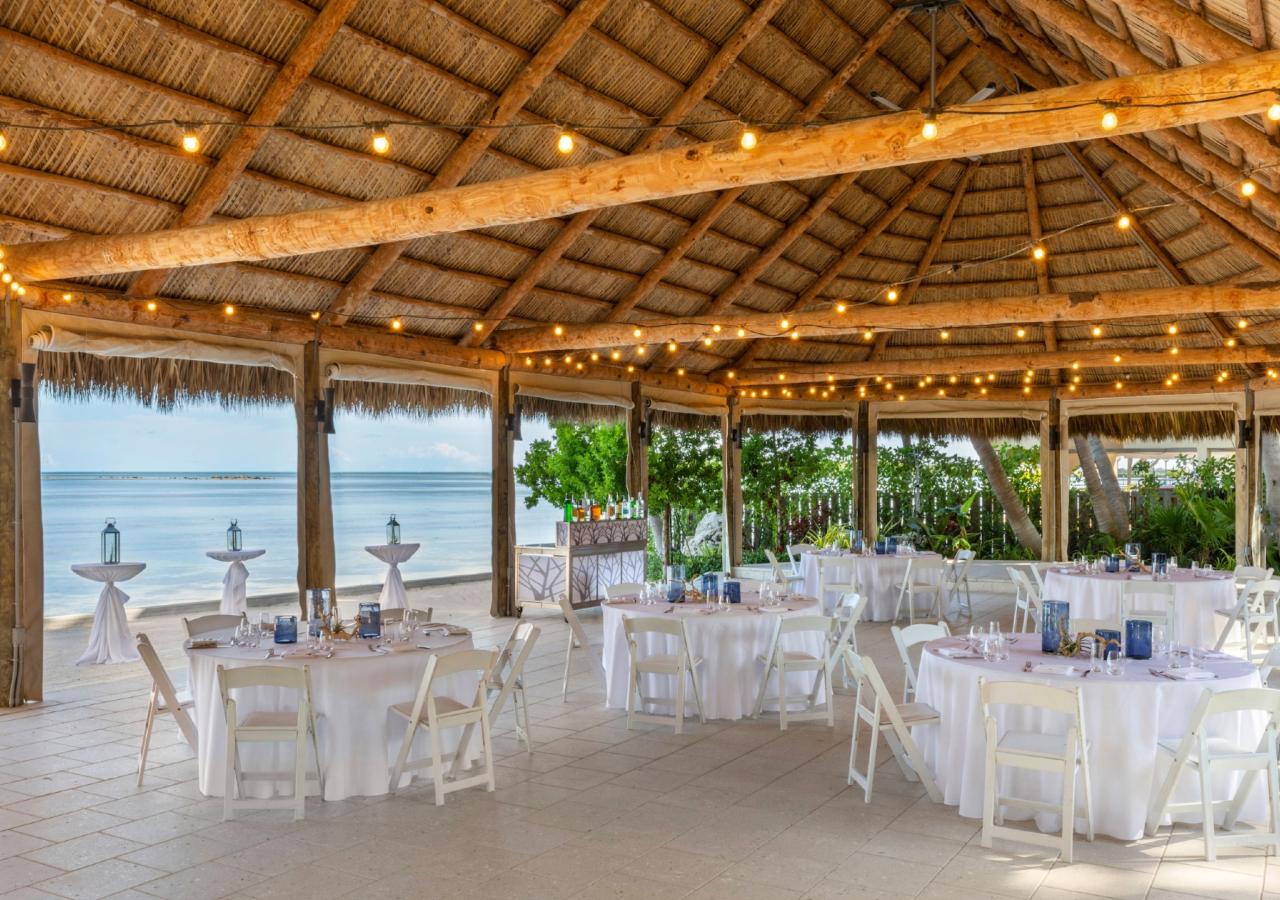 an outdoor tiki set up for a group dining event overlooking the ocean