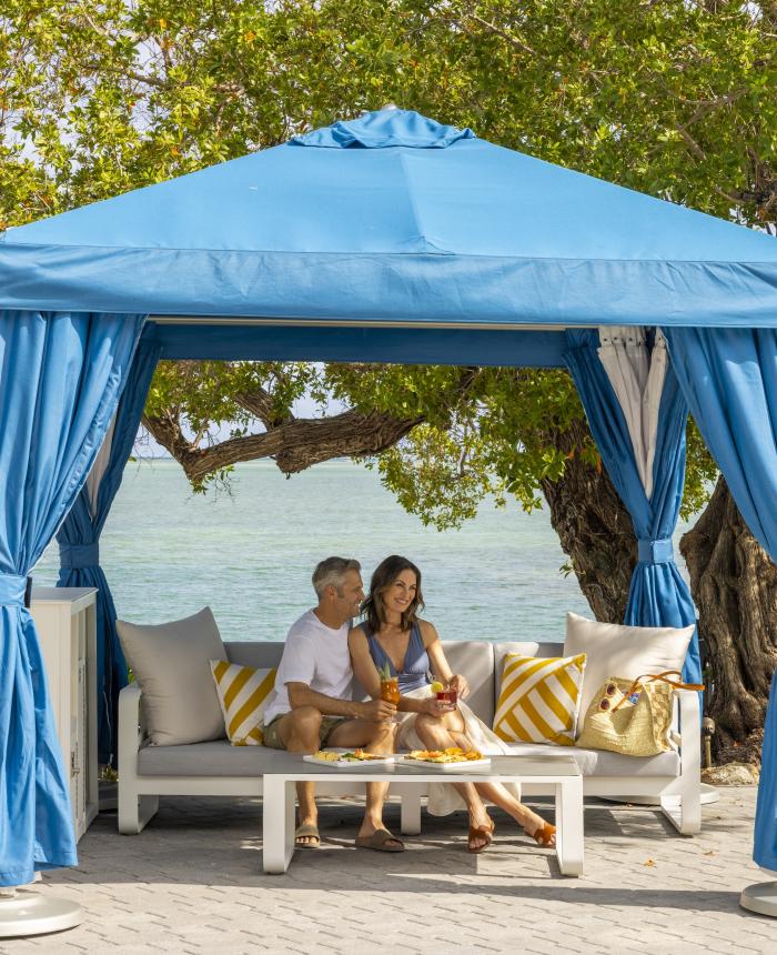 Couple sitting at a cabana with the ocean in the background