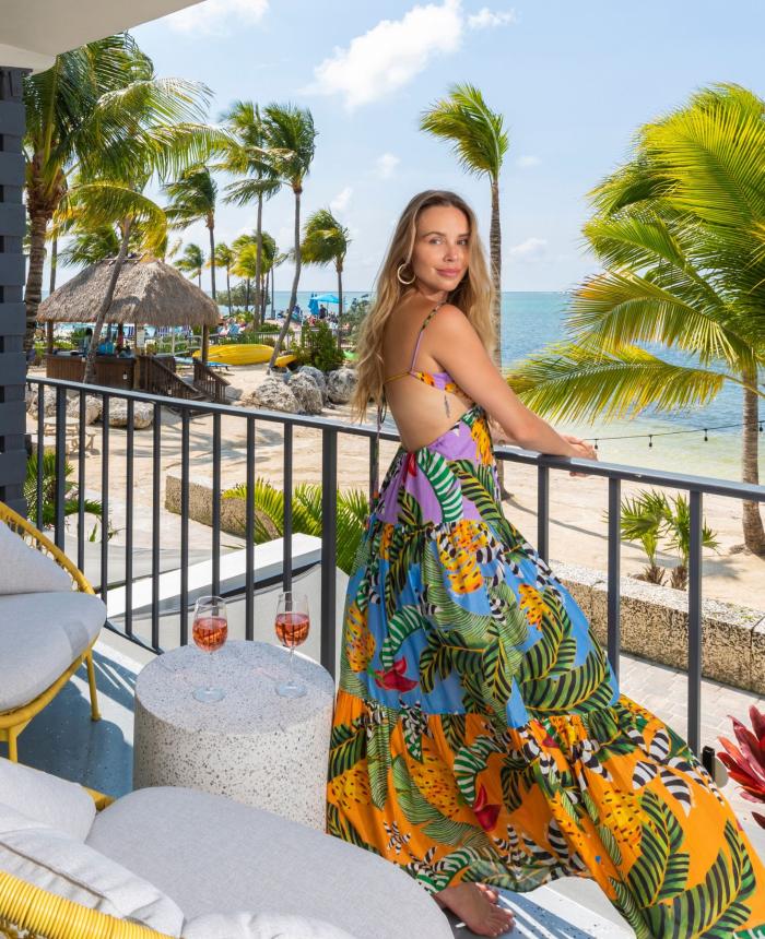 Woman standing on balcony overlooking the beach and ocean