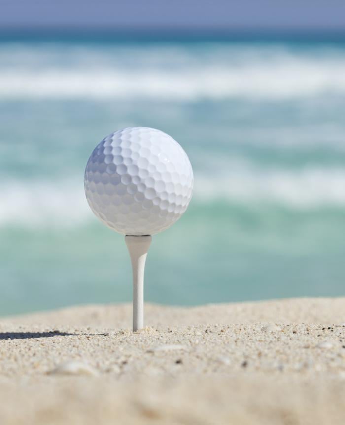 Golf ball on tee in the sand