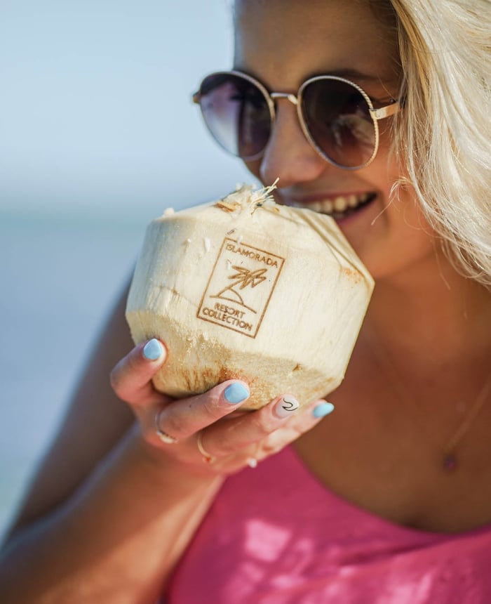 woman drinking from a branded coconut
