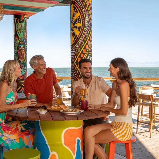 A group of people sitting at a table outside