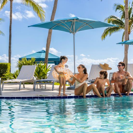 A family sitting by the pool at Three Waters Resort in Islamorada.