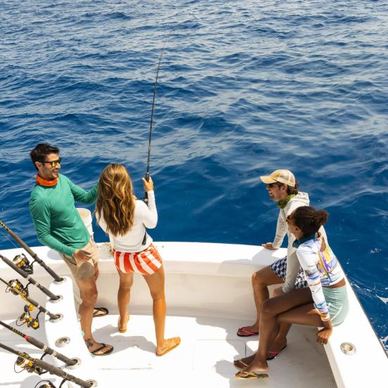 Group of people fishing on a boat in the ocean