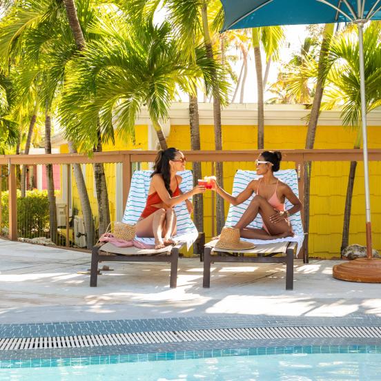 Two women sitting by the pool at La Siesta 