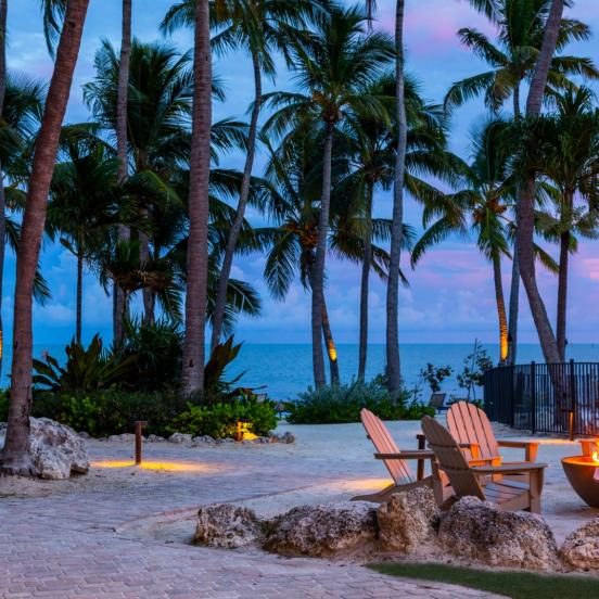 A sunset at Amara Cay with a firepit and chairs.