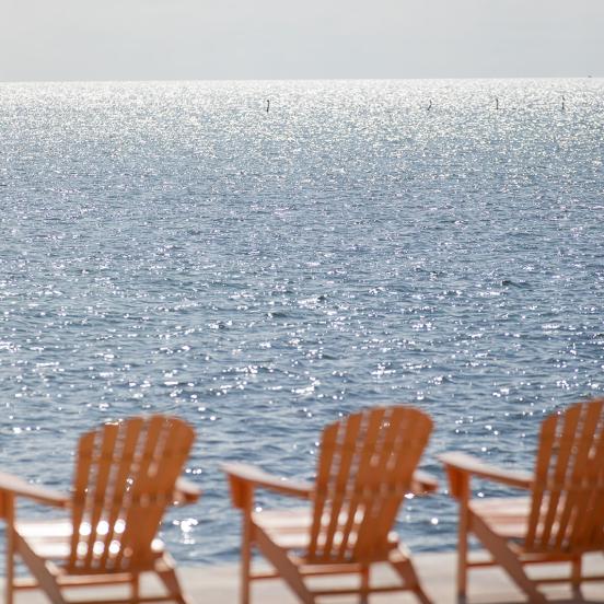 Coral Adirondack chairs next to the water at La Siesta in the Florida Keys.
