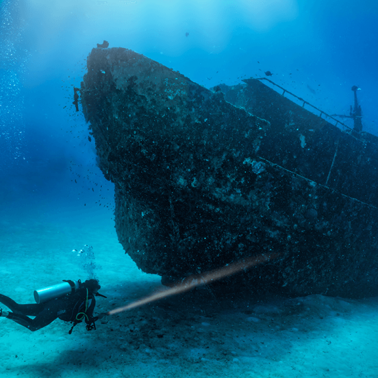person diving and exploring a shipwreck