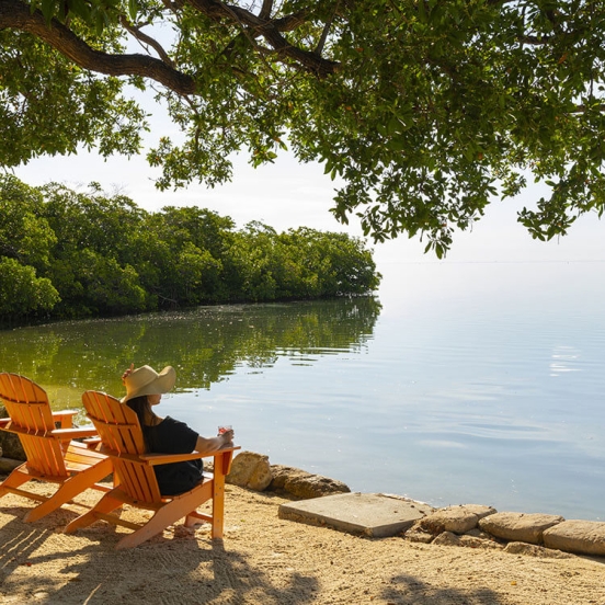woman sitting in an orange chair overlooking the water