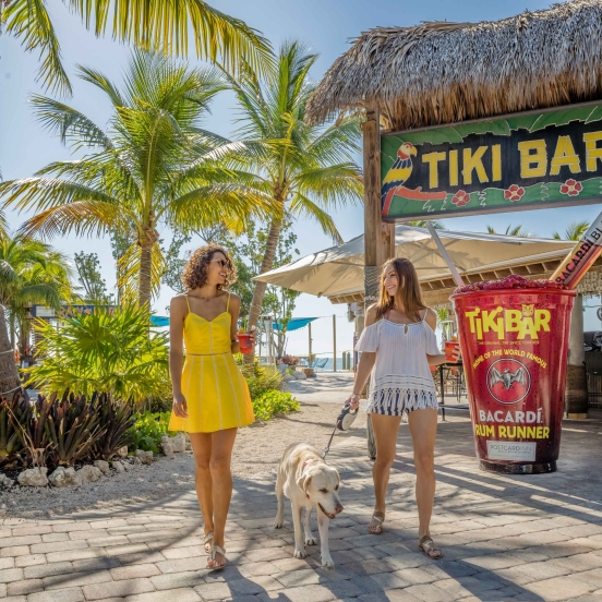 Women talking a dog outside the Tiki Bar entrance