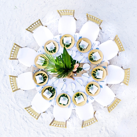 aerial view of a table set up for a wedding on the beach