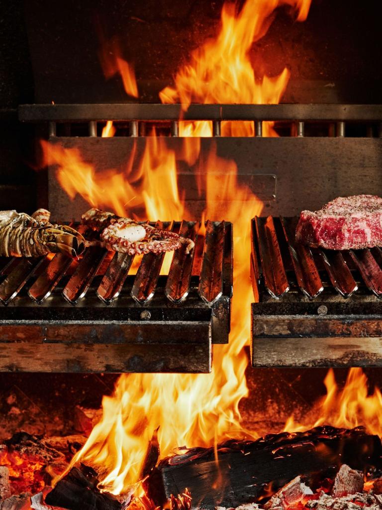 An open fire with steaks on it in Kindler in Islamorada.