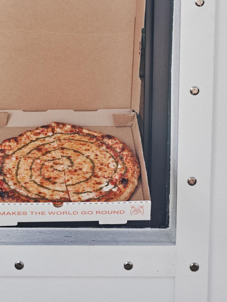 A full pizza in a takeout box.