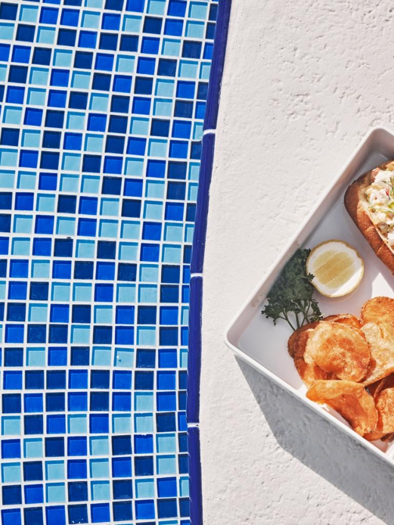 A plate of food sitting by the pool.