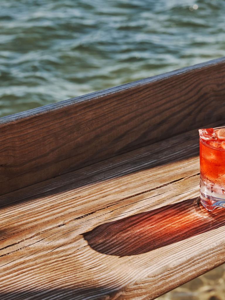 A drink on the table overlooking the water.