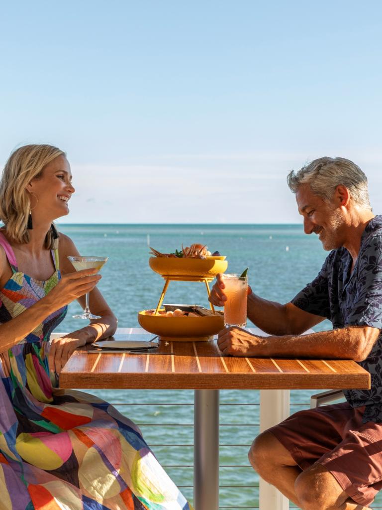 A couple enjoying dinner with an ocean front view.