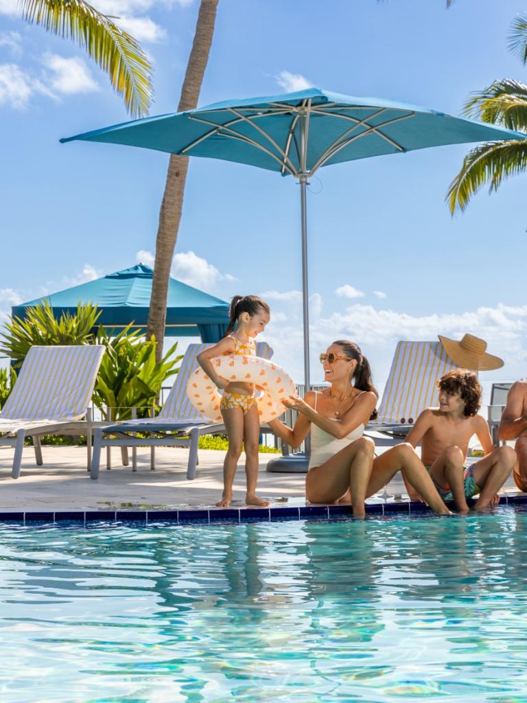 A family sitting by the pool at Three Waters Resort in Islamorada.