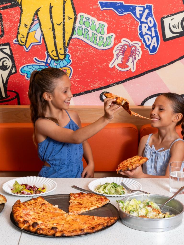 Two girls eating pizza.