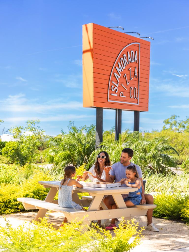 A family enjoying pizza outside.