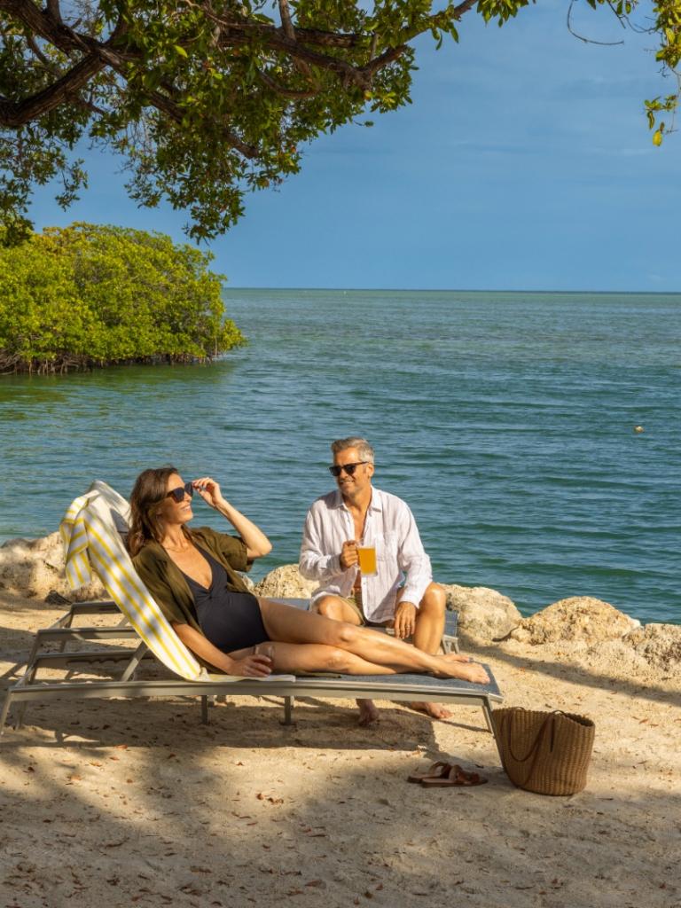 A couple sitting in the sun at the Cove at Three Waters in Islamorada, Florida.