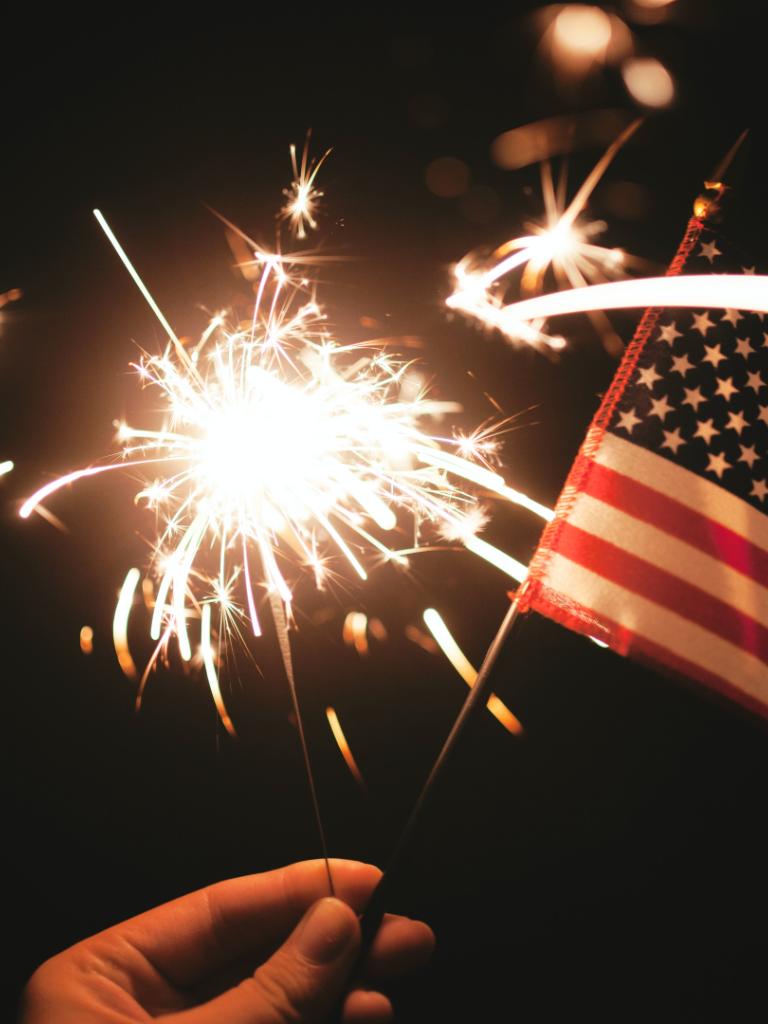 american flag with fireworks in the background