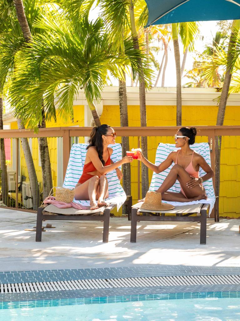 Two women sitting by the pool at La Siesta 