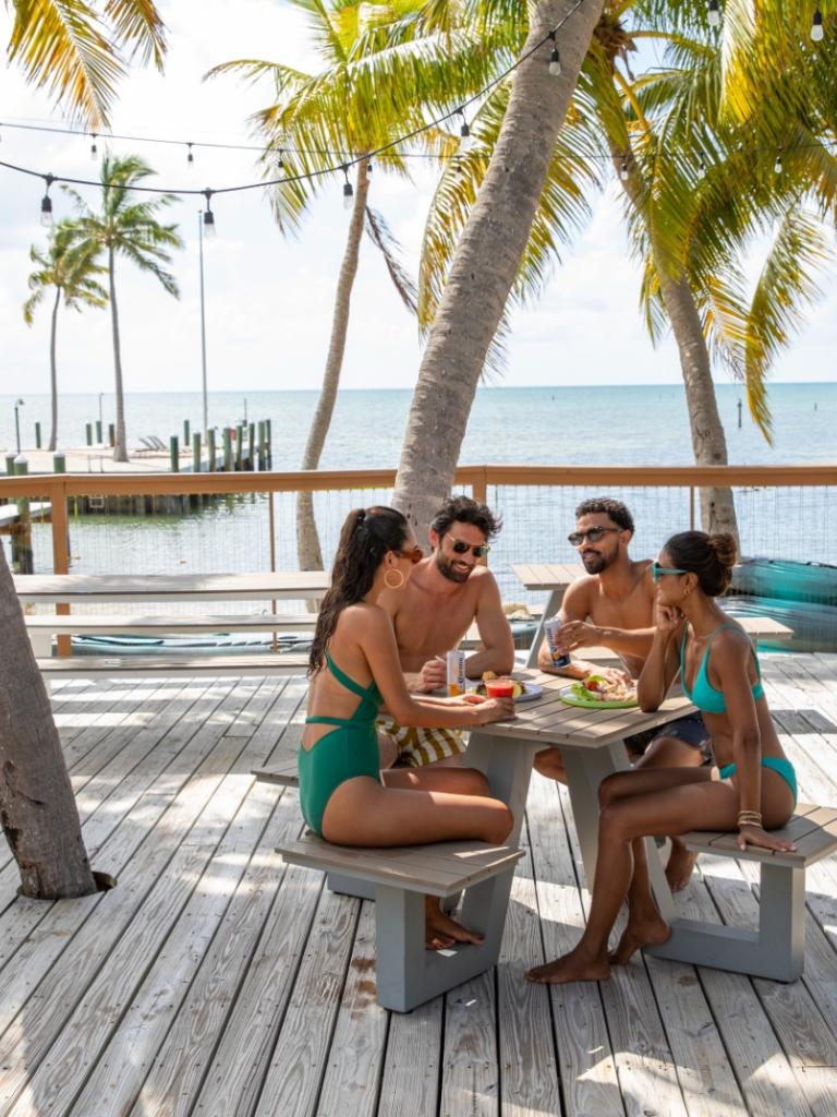Friends sitting at a table by the ocean at La Siesta in the Florida Keys.