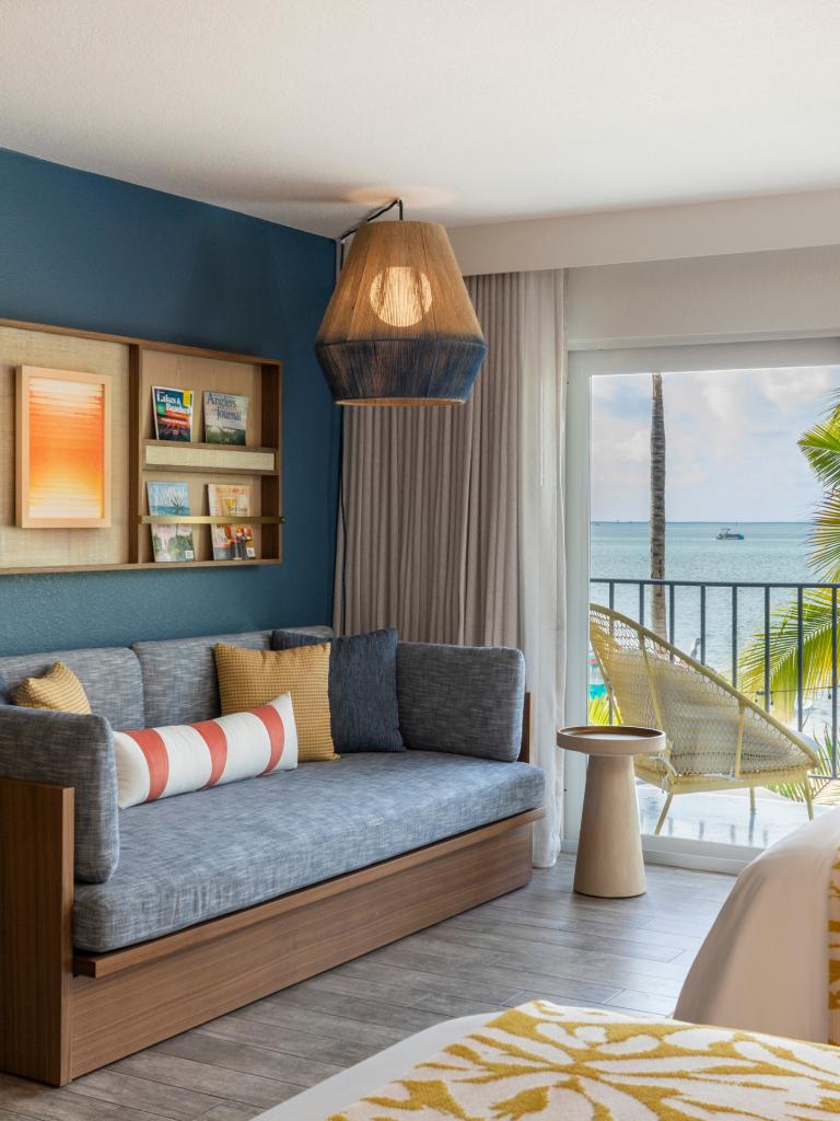 Room with 2 beds, couch and view of the ocean
