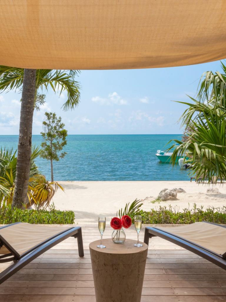 A lanai at La Siesta Resort & Villas. On the Lanai are two chairs with a table between them. 