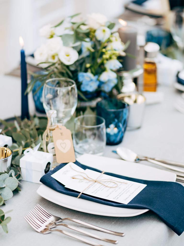 long table set up for a formal dinner, on the beach