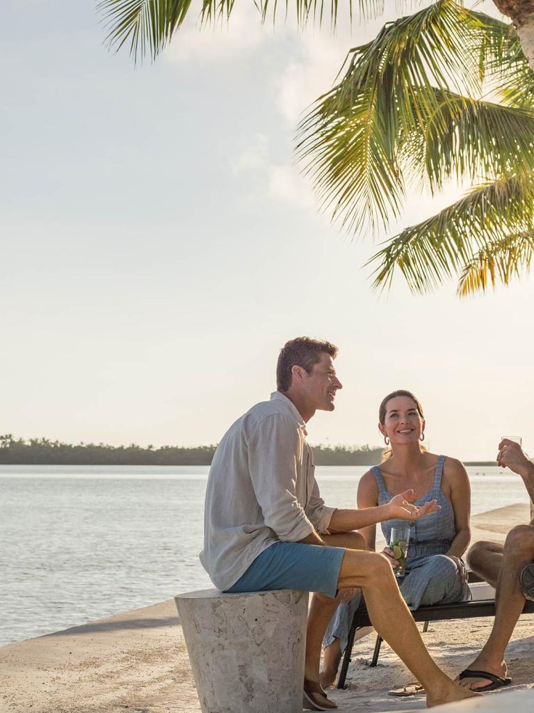 group on adults sitting on chairs on the beach