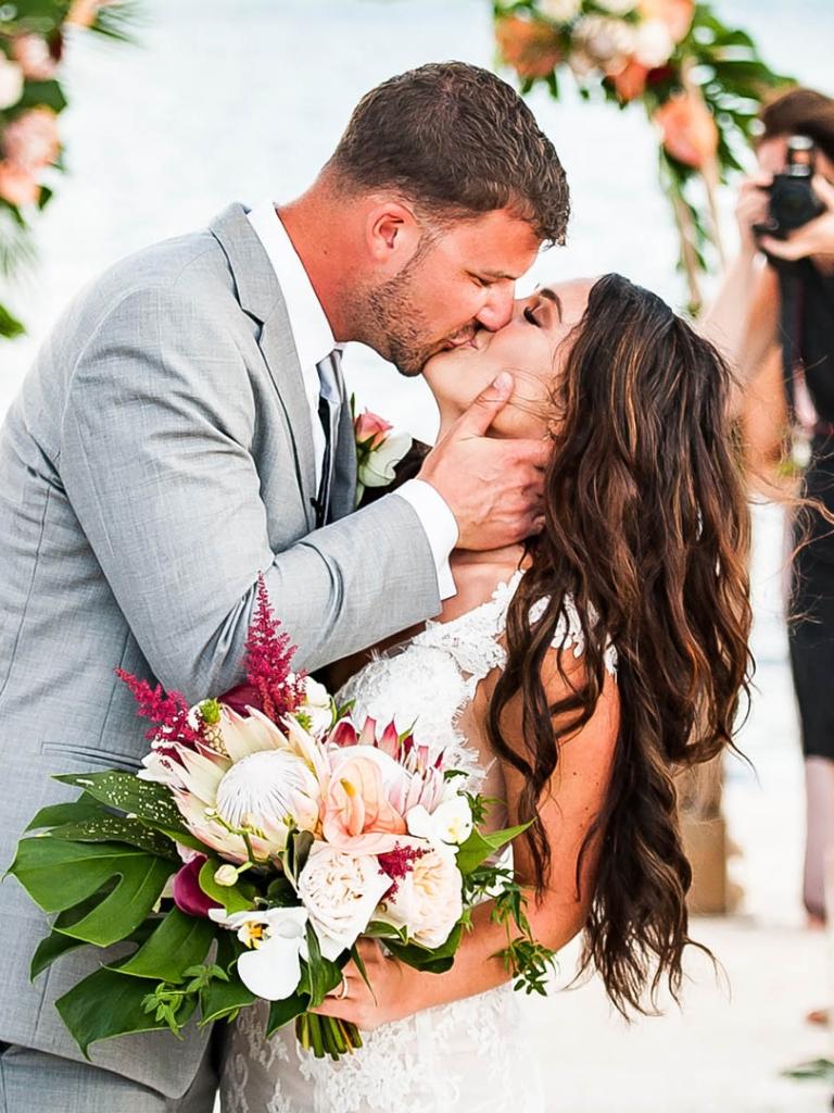 bride and groom kissing at the altar on the beach