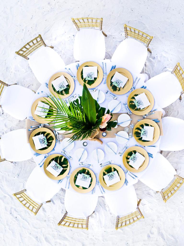 aerial view of a table set up for a wedding on the beach