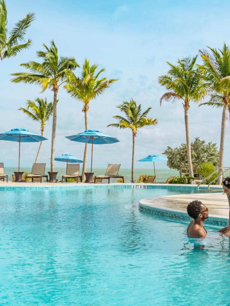 couple siting on the edge of a pool