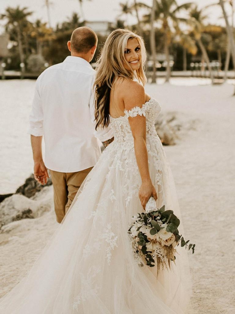 bride and groom walking on the beach