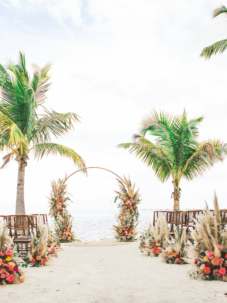 beach setting with wooden chairs and a wedding altar