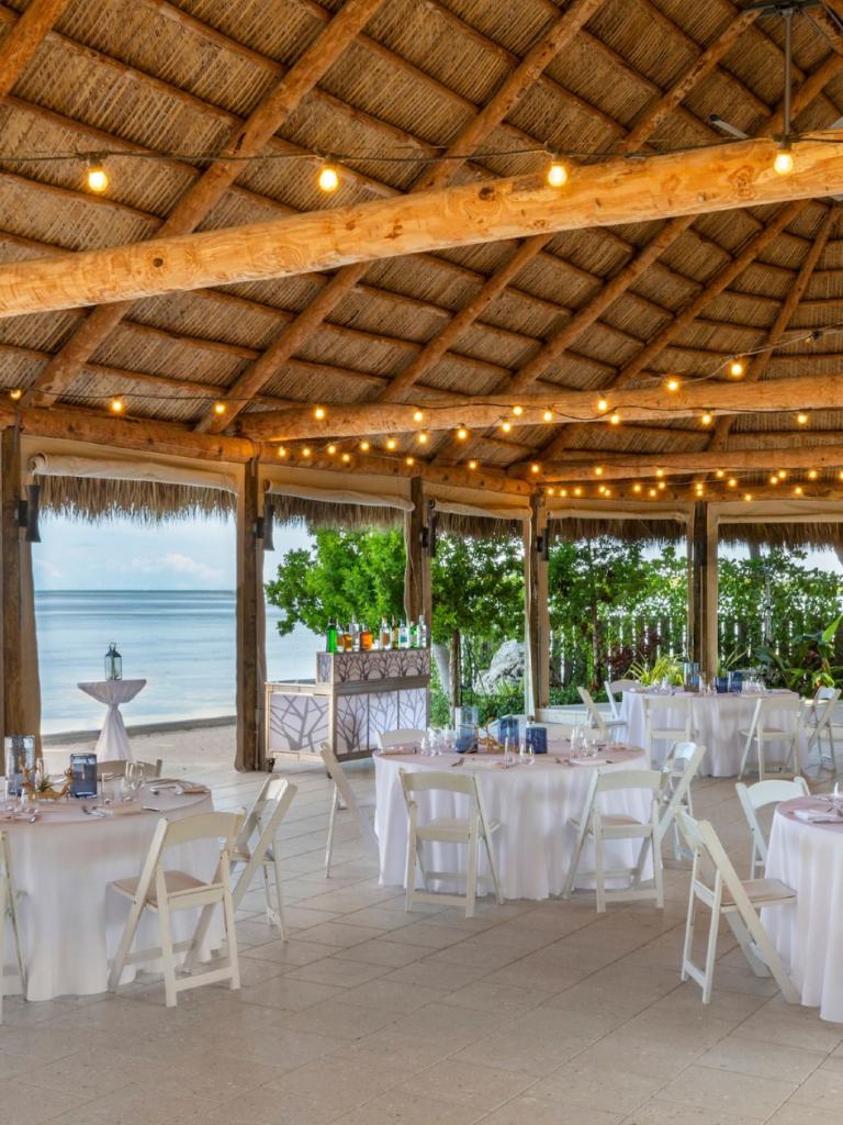 an outdoor tiki set up for a group dining event overlooking the ocean