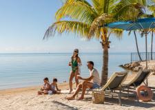 A family sitting at the beach together.