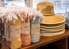 Beach towels and hats on a self in a retail store