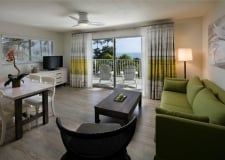 living room with green sofa and small dining area