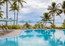 The pool at Amara Cay Resort with pool chairs and umbrellas 