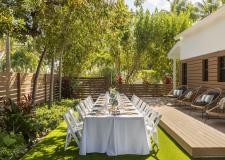 A La Siesta back garden set up with a long banquet table topped with white linens